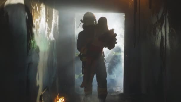 Strażak niosący dziecko heroicznie przez dym i ogień — Wideo stockowe