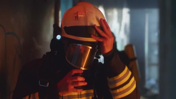 Pemadam kebakaran melepas perlengkapan pelindung setelah operasi penyelamatan — Stok Video