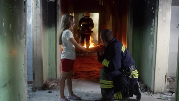 Bomberos hablando y dando juguete a la chica — Vídeos de Stock