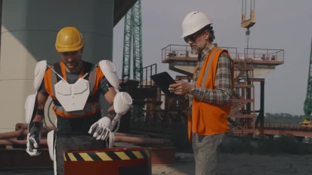 Angajat în exoschelet care transportă butoi după conversația cu supraveghetorul — Videoclip de stoc