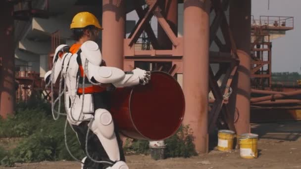 Male worker in exoskeleton delivering barrel to foreman — Stock Video