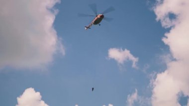 Gökyüzünde yangın söndürücü olan bir helikopter.