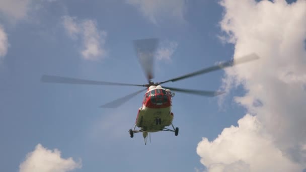 Emergency service helicopter flying against clouds — Stock Video