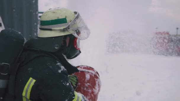 Пожарный вытирает маску с пены — стоковое видео