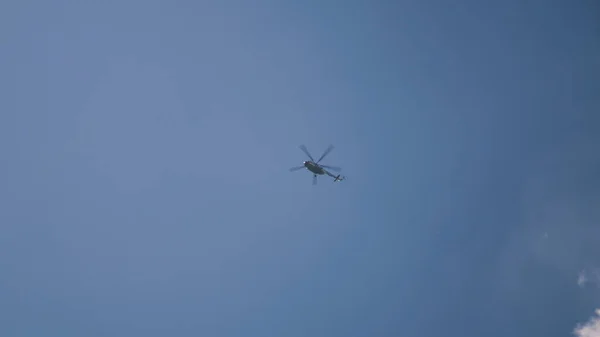 Parlak güneşe karşı uçan bir helikopter. — Stok fotoğraf