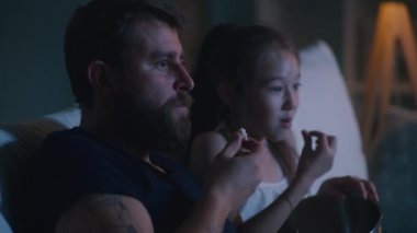 Baba ve kızı akşam film izliyorlar.