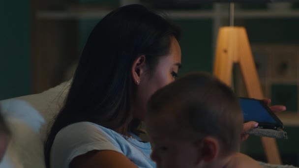 Азиатская мать делает видеозвонок на планшете — стоковое видео