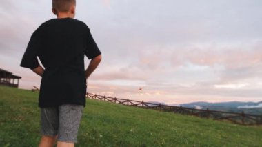 Çocuk dağlarda uçakla oynuyor.