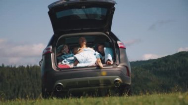 Anne ve çocuklar sabah araba bagajında.