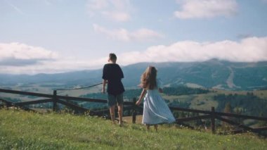 Rüzgarlı bir günde dağlara bakan çocuklar