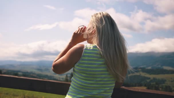 Γυναίκα πίνοντας ζεστό ρόφημα στα βουνά — Αρχείο Βίντεο