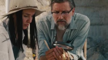 Arkeologlar birlikte antik kolyeyi analiz ediyorlar.