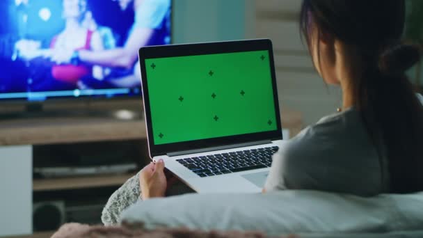 Anonieme vrouw met laptop rust in de buurt van TV — Stockvideo