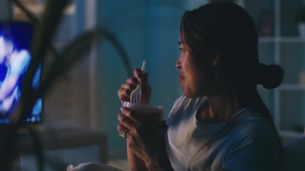 アジアの女性はテレビを食べて見て — ストック動画