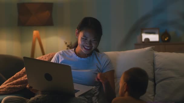 Madre haciendo videollamada cerca de hijo por la noche — Vídeos de Stock