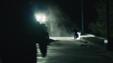 Denetmen geceleri çalışanlara doğru yürüyor.