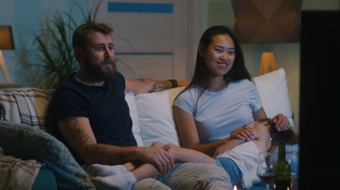 Çeşitli aileler kanepede film tartışıyor.