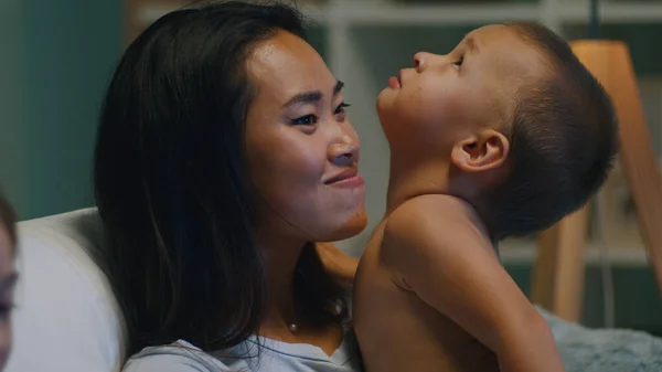 Asiatisk mor tittar på TV med barn — Stockfoto