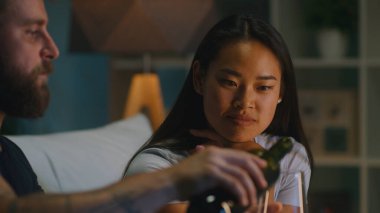 Çeşitli çiftler oturma odasında şarap içiyor.