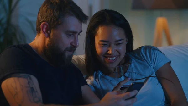 Olika par använder smartphone på soffan — Stockfoto