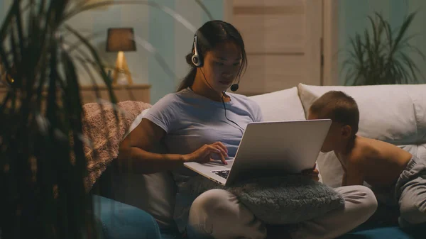 Asiatisk mamma använder laptop nära son — Stockfoto