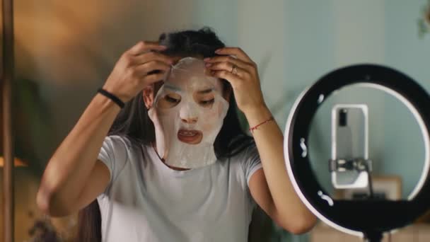 Skönhetsbloggare som applicerar sheet mask — Stockvideo