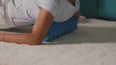 Anne, oğlunun yanında köpük rulo üzerinde egzersiz yapıyor.