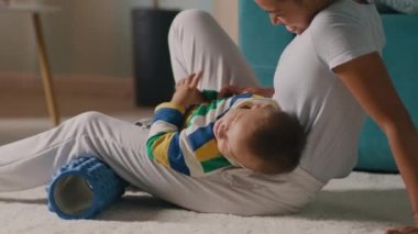 Anneler evde antrenman yaparken oğullarıyla oynuyorlar.