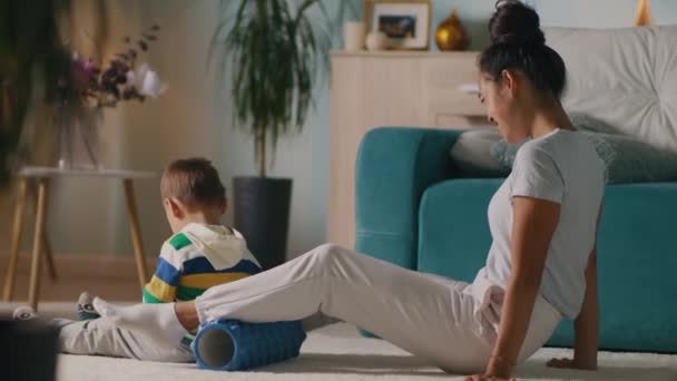 Lycklig kvinna motionerar nära leker pojke — Stockvideo