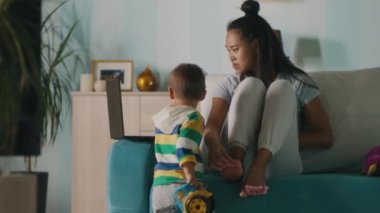 Asyalı anne video izleyip pedikür yapıyor.