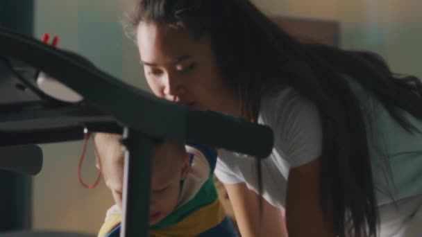 Ibu menempatkan anak di treadmill — Stok Video