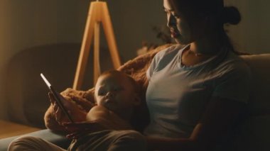 Çocuklu Asyalı anne gece film izliyor.