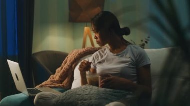 Yemek sırasında film izleyen Asyalı kadın.