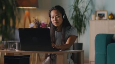 Asyalı kadın evde online konferans veriyor.