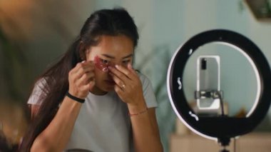 Asyalı güzellik blogcusu göz bandı yapıştırıyor