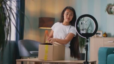 Asyalı blogcu evde paket açıyor
