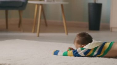 Anne oğluyla oturma odasında oynuyor.