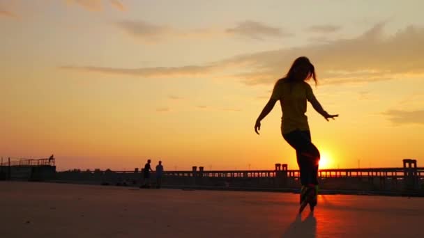 Gün batımında köprüdeki kız paten — Stok video