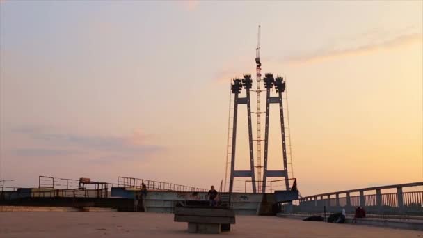 Ролик робить трюк на мосту на заході сонця — стокове відео