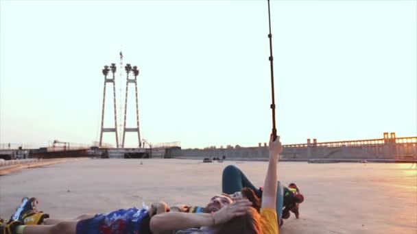 Rouleau mensonge et faire selfie sur pont au coucher du soleil — Video