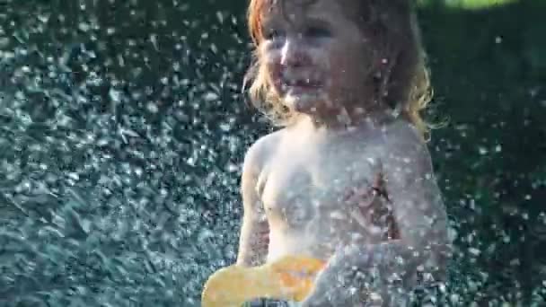 Mädchen schüttet Wasser aus Schlauch — Stockvideo