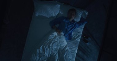 İnsan uykusuzluk ve saplantılı düşüncelerden muzdarip. Gri saçlı adam yatakta dönüp duruyor, uykuya dalmaya çalışıyor. Yaşla ilgili uyku bozuklukları, endişe, gece rutinleri kavramı. Üst Görünüm Döndürülüyor.