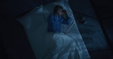 İnsan uykusuzluk ve saplantılı düşüncelerden muzdarip. Gri saçlı adam yatakta dönüp duruyor, uykuya dalmaya çalışıyor. Yaşla ilgili uyku bozuklukları, endişe, gece rutinleri kavramı. Üst Görünüm Döndürülüyor.