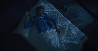 İnsan uykusuzluk ve saplantılı düşüncelerden muzdarip. Gri saçlı adam yatakta dönüp duruyor, uykuya dalmaya çalışıyor. Yaşla ilgili uyku bozuklukları, endişe, gece rutinleri kavramı. Üst Görünüm Döndürülüyor.