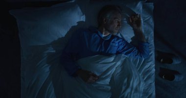 Geceleri, gri saçlı adam zor bir günden sonra pek çok düşünce yüzünden uyuyamaz. Adam Yataktan Kalkar ve Karanlık Yatak Odasından Gider. Yalnızlık ve Uykusuz Düşünceler kavramı. Üst Görünüm Döndürülüyor.