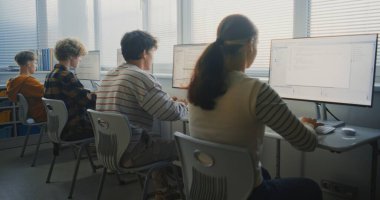 Parlak Sınıflar Öğrenme Yazılım Geliştirme Bölümü 'ndeki genç öğrenciler. Odaklanmış Grup Bilgisayar Kodu Monitörler, Keşif Programı, Takım Çalışması, Dijital Gelecek Yetenekleri. Geriye bak. Sabit Çekim.