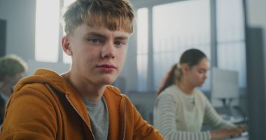 Sınıfta Yakışıklı Öğrenci Geliştirme Oyunu üzerine çalışıyor. Yeşil Gözlü Genç, Programlama Öğrenirken Kamera 'ya Yoğun Bakıyor. Dijital Eğitim, BTMM Eğitim, Yaratıcı Yetenekler. Portre.