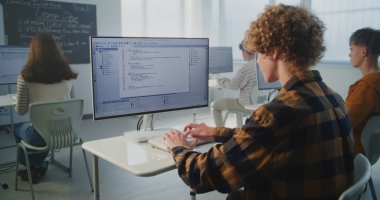 Odaklanmış Öğrenci Bilgisayar Kodu Klavyeye Çabuk. Erkek Öğrenci Sınıfta Masada Oturuyor, İsteyerek Program Kodu Yazıyor. Modern Eğitim ve Gelecek Teknoloji Becerileri kavramı. Sabit Çekim.