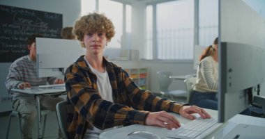 Kıvırcık Saçlı Genç Adam Oyun Geliştirme Projesinde çalışıyor. Öğrenci Programlama ve Tasarım, Kameraya İsteyerek Bakma. Dijital Eğitim, Teknoloji ve Yaratıcı Yetenekler kavramını benimse. Portre.