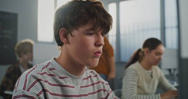 Çizgili Kazaklı Kahverengi Gözlü Çocuk Bilgisayar 'da çalışıyor, Kameraya Yakından Bakıyor. Bilgisayar Laboratuvarında 3D Modellik Öğrencileri. BTMM Eğitim, Yaratıcı Meslekler kavramı. Portre.